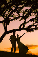 silhouette of a just married bride and groom on a sunset