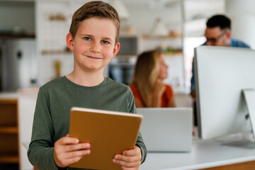 Home schooling social distance e-learning online education concept. Happy boy using tablet at home.