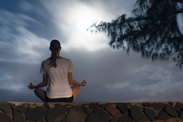 Young woman meditating in the moon light