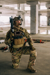 Special forces operator wearing Multicam uniform and his assault rifle HK 416 while practicing CQB combat training in the abandoned building. Coyote brown and mc gear in the urban environment.