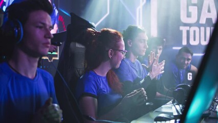 Anxious esportsman gamer woman exhaling and communicating with teammates while preparing for professional esports tournament