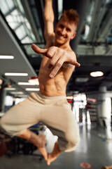 Fototapeta na wymiar handsome sportman having fun at gym smiling with tongue out showing fingers victory sign.