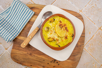 scallop and mussel gratin on a white plate on a table