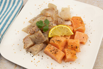 cut salmon and coalfish on a white background with parsley and lemon on a table