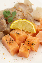cut salmon and coalfish on a white background with parsley and lemon