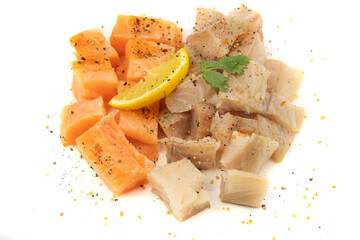 cut salmon and coalfish on a white background with parsley and lemon