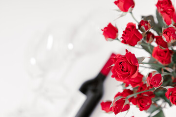 Red roses, flowers bouquet, wine and glasses for wine on white background. Women's Day, Valentine's Day, 8 March, Birthday. Flat lay, top view, copy space