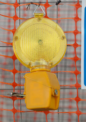 Emergency Flashing LED hanging on welded Wire. Construction site protected with barrier net