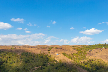 yellow grass mountain range with bright blue sky at morning from flat angle