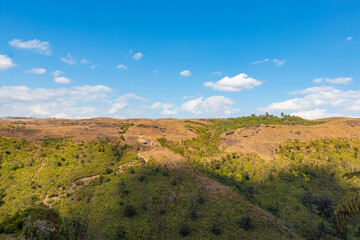 yellow grass mountain range with bright blue sky at morning from flat angle