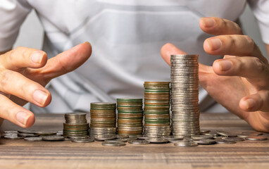 In the shape of a bar graph, a man gathers coins.