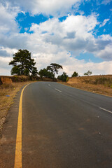 Fototapeta na wymiar isolated countryside tarmac road with bright blue sky at morning from flat angle