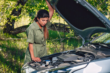 young beautiful girl leaned on the hood and thinking how to fix her car