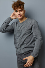 stylish guy in a gray sweatshirt fashion studio Gray background