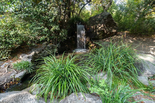 The stream flows down over the kms among the green grass