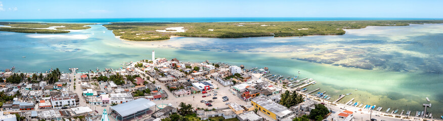Fototapeta na wymiar Aerial landscape overlooking the city of Rio Lagartos. The city is surrounded by a beautiful river with azure water. Fishing boats are moored to the shore. Yucatan, Mexico