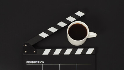 Black Clapper board and hot coffee white cup on black background.
