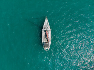 Aerial drone bird's eye view photo of huge white sail boat cruising in open deep blue sea