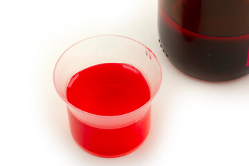 cough syrup in measuring cup