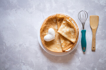 Creative breakfast for Valentine's Day. Heart shaped pancakes with strawberries on a plate, on a marble background. Valentine's day background. View from above. Flat lay. copy space