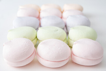 Delicate pattern of multi-colored pastel marshmallows on a light background, macro. Pastel marshmallows as a background
