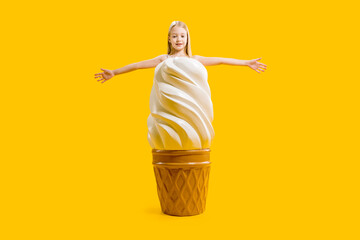 A huge delicious appetizing dessert. A girl stands behind a large ice cream with her arms outstretched to the sides.
