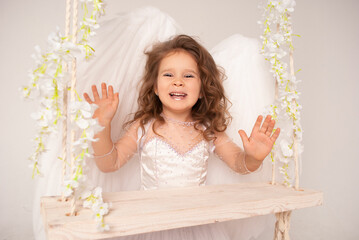 a little sweet girl with a charming laugh in an angel costume for Valentine's Day, lovers or...