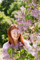 Cheerful woman in a lilac garden