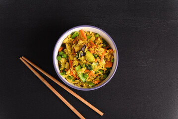 Rice with vegetables and yellow seasoning in a plate.