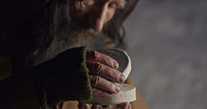 Aged monk with golden bitcoin in cave