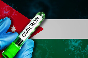 Jordan outbreak of omicron variant. Hand holds a test tube with covid-19 virus omicron in front of...