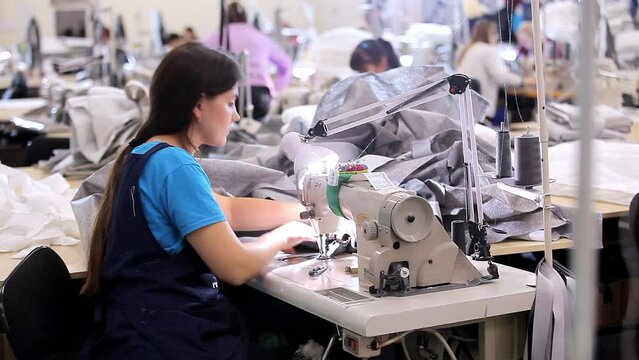 A seamstress works at a sewing factory. sewing production. Home textile production. Large sewing workshop