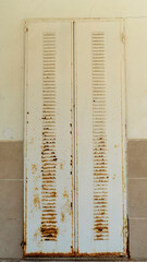 rusted iron shutter. Rusted shutter of old house door. Rusty shutter that needs remodeling. blinds with damaged paint. An image that construction companies can use for home decoration and home remodel