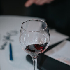 Glass of red wine in hand at a special event, a specific tasting of alcoholic beverages.