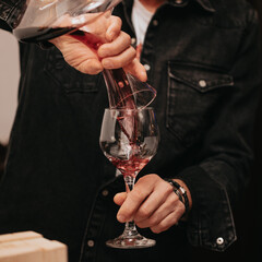 Glass of red wine in hand at a special event, a specific tasting of alcoholic beverages. - 482810498