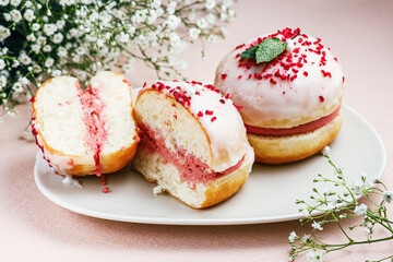 Berliner with pink filling on a pink napkin