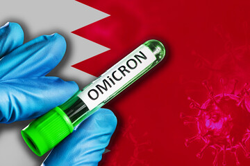 Bahrain outbreak of omicron variant. Hand holds a test tube with covid-19 virus omicron in front of...