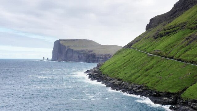 Beautiful aerial view of Risin and Kellingin, the giant and the witch view in the Faroe Island.Ocean waves on rock beach,sea foam in background,green mountain,wild nature,wild no people