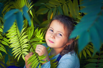 Close-up portrait of a little girl in the trees