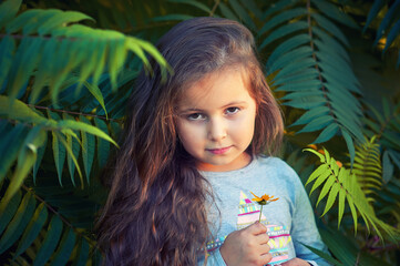 Close-up portrait of a little girl in the trees
