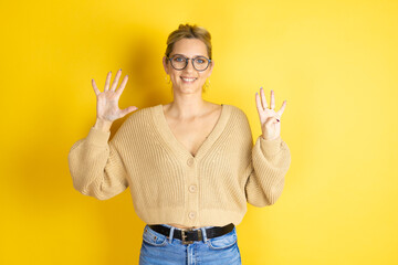 Young beautiful woman wearing casual sweater over isolated yellow background showing and pointing...