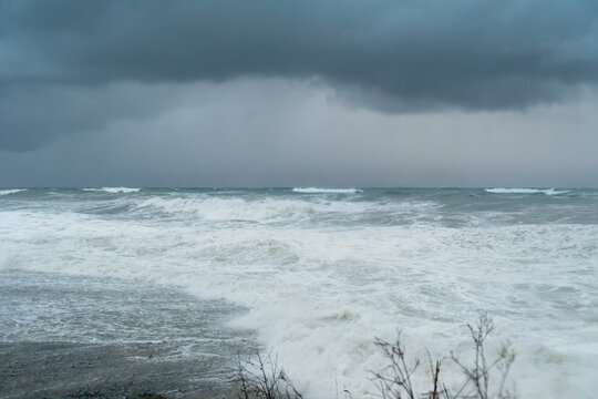 Beautiful seascape with a raging sea, huge waves rolling on the shore, storm clouds
