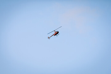 Silhouette of a chopper high in the blue sky seen from below, the military maneuvers; worm’s eye...