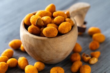 Chili roasted peanuts on dark wooden background. Delicious snack peanut.