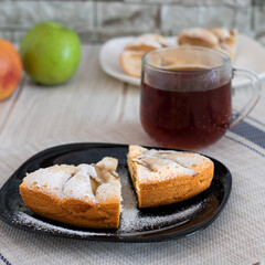 A piece of fresh apple pie with a cup of hot tea