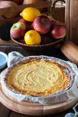 Homemade ricotta pie serving on a wooden board on a wooden background.