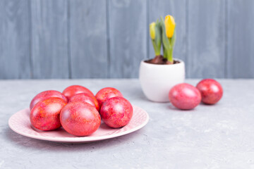 Decorated Easter eggs on pink ceramic plate and gray marble table