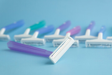 Set of multi-colored disposable razors on a blue background