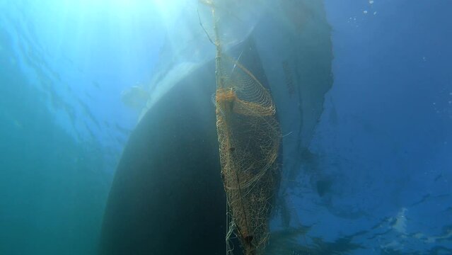 4K.Caught fish in the net hanging from the boat under the sea.Underwater fishing of deep blue ocean.Fish caught in spiral line fishing nets.Tulle stretching into infinity.Trap snare ambush decoy lure 