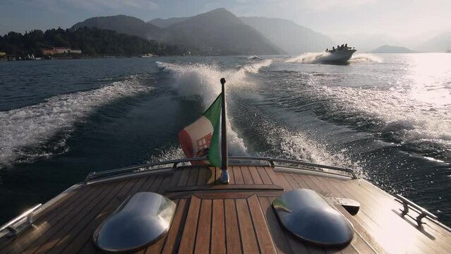 Luxury motor boat trip at Lake Como valley under Italian flag at romantic honeymoon. Luxury wedding and holiday concept. 4k high quality slow motion cinematic footage